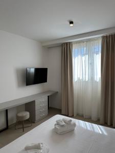 una camera con letto, scrivania e TV di Amani Chic Rooms a Olbia