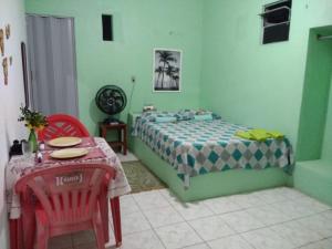 Schlafzimmer mit einem Bett, einem Tisch und Stühlen in der Unterkunft Casa Laranja in Cascavel