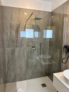 una doccia con porta in vetro in bagno di Amani Chic Rooms a Olbia