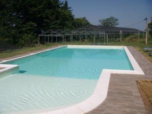 a large swimming pool with blue water in a yard at Agriturismo Prato Fiorito in Bagni di Lucca