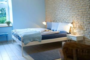 Bett in einem Zimmer mit Ziegelwand in der Unterkunft Apartmán U Pomněnky in Jeseník