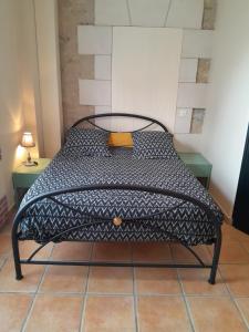 un letto con piumone bianco e nero in una stanza di Le Relais du Jardin a Orbigny
