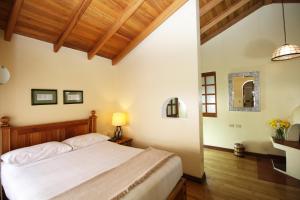 1 dormitorio con cama y techo de madera en Hotel Vieja Cuba en Quito