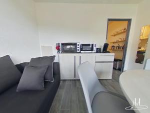 ein Wohnzimmer mit einem Sofa und einer Mikrowelle in der Unterkunft Studio 503, La Bresse Hohneck in La Bresse