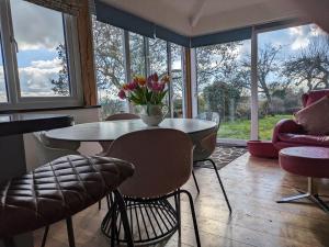 a living room with a table with a vase of flowers on it at Pool Farm in Redditch