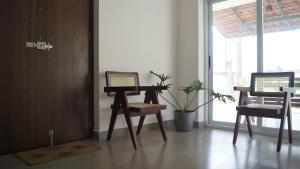 two chairs and a table in a room with a window at Blue Lake Villa in Kollam