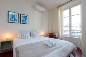 une chambre avec un lit blanc avec deux serviettes dessus dans l'établissement Villa CANA, à Cannes