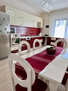 eine Küche mit einem weißen Tisch und weißen Stühlen in der Unterkunft New Bazaar Cozy Apartments Apartment 1 Apartment 2 in Tirana