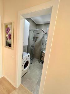 ein Bad mit einer Waschmaschine und einer Dusche in der Unterkunft New Bazaar Cozy Apartments Apartment 1 Apartment 2 in Tirana