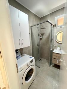 eine Waschmaschine im Bad mit Dusche in der Unterkunft New Bazaar Cozy Apartments Apartment 1 Apartment 2 in Tirana