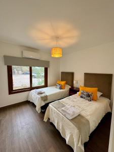 a room with two beds and a large window at BuenaVid estancias in Cafayate