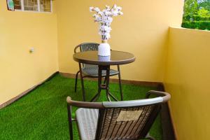 a table and a chair with a vase of flowers on it at jenna stays in Nyeri