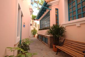 a bench in a courtyard of a building with plants at Hotel Vieja Cuba in Quito