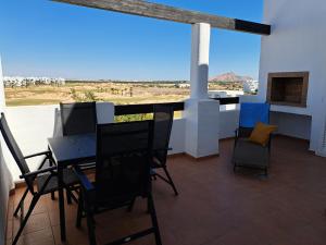 una mesa y sillas en un balcón con vistas al desierto en Casa Raya, en Roldán