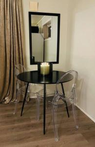 a table with a candle and two chairs and a mirror at Leilighet i nord in Tromsø +12 photos