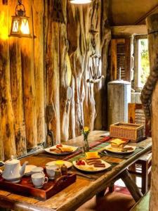 een houten tafel met borden eten erop bij Villa 47 in Nuwara Eliya