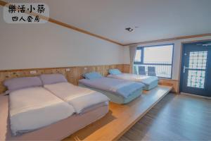 a room with two beds and a large window at 江山樂活Lohas in Puli