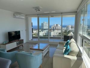 sala de estar con sofá blanco y ventana grande en Apartamento 901 torre One II, en Punta del Este