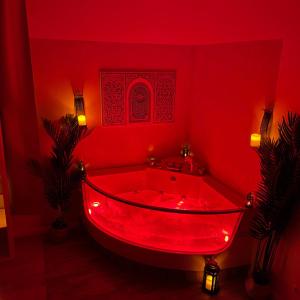 bañera roja en una habitación roja con luces en Appartement avec Balneo - Casa casbah en Saint-Ouen