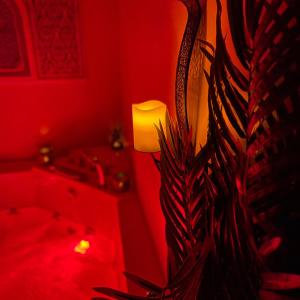 una habitación roja con una lámpara y una planta en Appartement avec Balneo - Casa casbah en Saint-Ouen