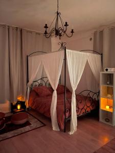 1 dormitorio con 2 camas, cortinas y lámpara de araña en Appartement avec Balneo - Casa casbah en Saint-Ouen