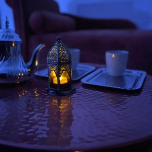 un candelabro en una mesa con una taza y una tetera en Appartement avec Balneo - Casa casbah en Saint-Ouen