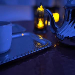 una mesa con un plato y una taza y una tetera en Appartement avec Balneo - Casa casbah en Saint-Ouen