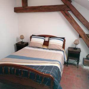 a bedroom with a large bed with two tables at Vallée du Serein in Marcilly-Ogny