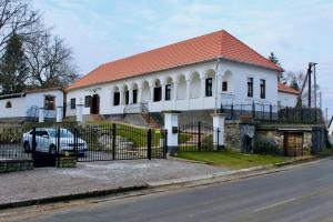 a white house with a car parked in front of it at Antik Vendégház in Nagyvisnyó