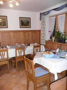 a dining room with two tables and chairs at Landhaus Caesar - Hotel Garni in Bad Heilbrunn
