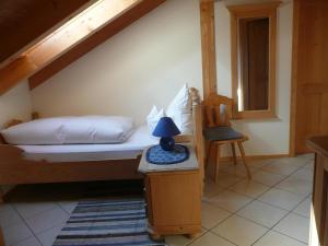 ein Schlafzimmer mit einem Bett und einer Lampe auf einem Tisch in der Unterkunft Landhaus Caesar - Hotel Garni in Bad Heilbrunn