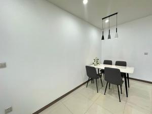 a white dining room with a table and chairs at Qhome in Ho Chi Minh City