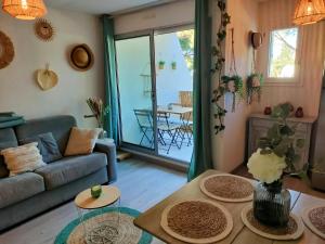 ein Wohnzimmer mit einem Sofa und einem Tisch in der Unterkunft L Or des sables, la Petite Motte, residence avec piscine in La Grande-Motte