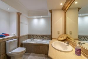 a bathroom with a sink and a toilet and a tub at Beachfront Seaview in Cape Town +11 photos