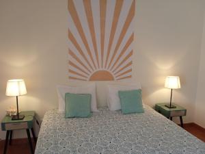 um quarto com uma cama com almofadas e 2 candeeiros em Hakuna Matata Hostel em Zambujeira do Mar