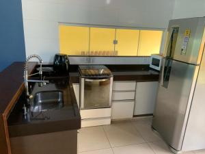 eine kleine Küche mit Spüle und Kühlschrank in der Unterkunft Casa no Sítio - Vovó Lalá in Cabo Frio
