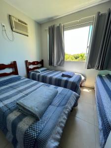 zwei Betten in einem Zimmer mit Fenster in der Unterkunft Casa no Sítio - Vovó Lalá in Cabo Frio