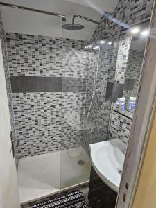 een badkamer met een douche, een wastafel en een toilet bij Appartement meublé , 1 chambre in Magnanville