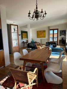 - un salon avec une table et des chaises en bois dans l'établissement Superbe T4 vue mer à Royan, 2 min à pied des plages, à Royan