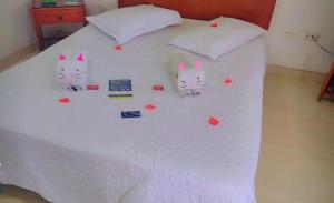 a bed with two cats with hearts on it at Hotel Estambul in Dosquebradas