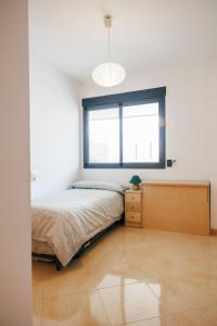 1 dormitorio con cama y ventana en Lujoso apartamento de dos habitaciones en la playa de Canet en Canet de Berenguer