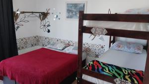 a bedroom with two bunk beds and a red blanket at FrenteMar OuroVerde BetoCarrero in Navegantes