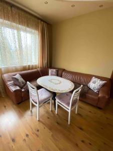 ein Wohnzimmer mit einem Tisch und einem Sofa in der Unterkunft Готель Алекс in Luzk