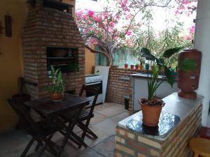 a patio with a table and a brick fireplace at Casa Laranja in Cascavel