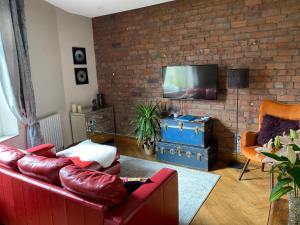 a living room with a red couch and a brick wall at Top O’ Th’ House . Hebden Bridge in Hebden Bridge