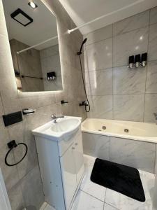 a bathroom with a sink and a tub and a mirror at Patagonia House - Mayo in Puerto Madryn