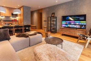 a living room with a large flat screen tv at Tarter Mountain & SPA - Gym - Pool - Sauna - Walk To Slopes l by BonesVacances in El Tarter