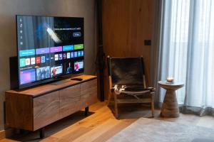 a living room with a flat screen tv and a chair at Tarter Mountain & SPA in El Tarter