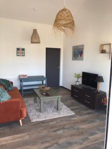 ein Wohnzimmer mit einem Sofa und einem Tisch in der Unterkunft Charmante Maison, terrasse vue mer in Les Sables-dʼOlonne