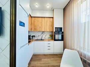 uma cozinha com armários brancos e uma janela em Кок Жайлау apartament em Astana